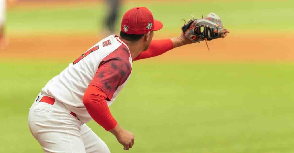 Yariel Rodríguez, a pitcher in a red cap and jersey, prepares to throw a baseball, showcasing focused determination on the field."